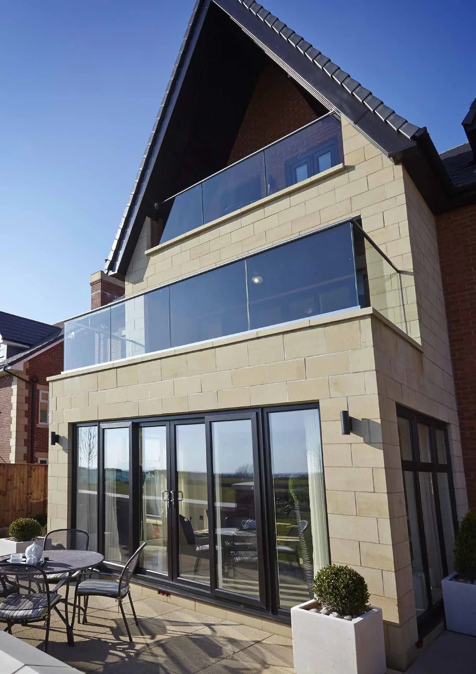 Modern home with sliding doors and a glass balcony – Roundhay Windows And Doors