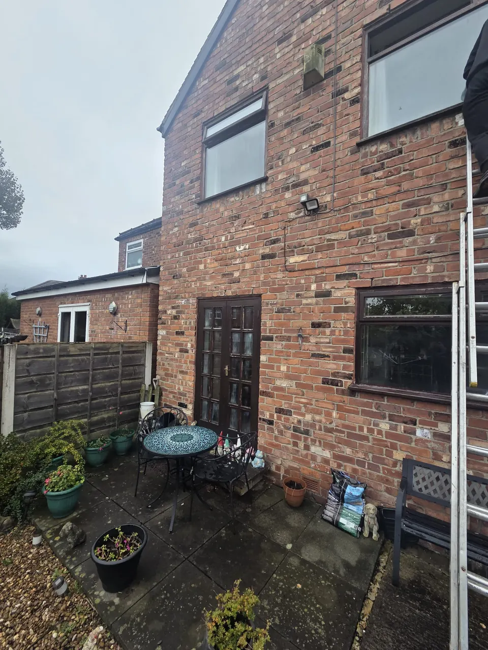 Before: old brown window frames on the back of a brick house in Alwoodley, Leeds